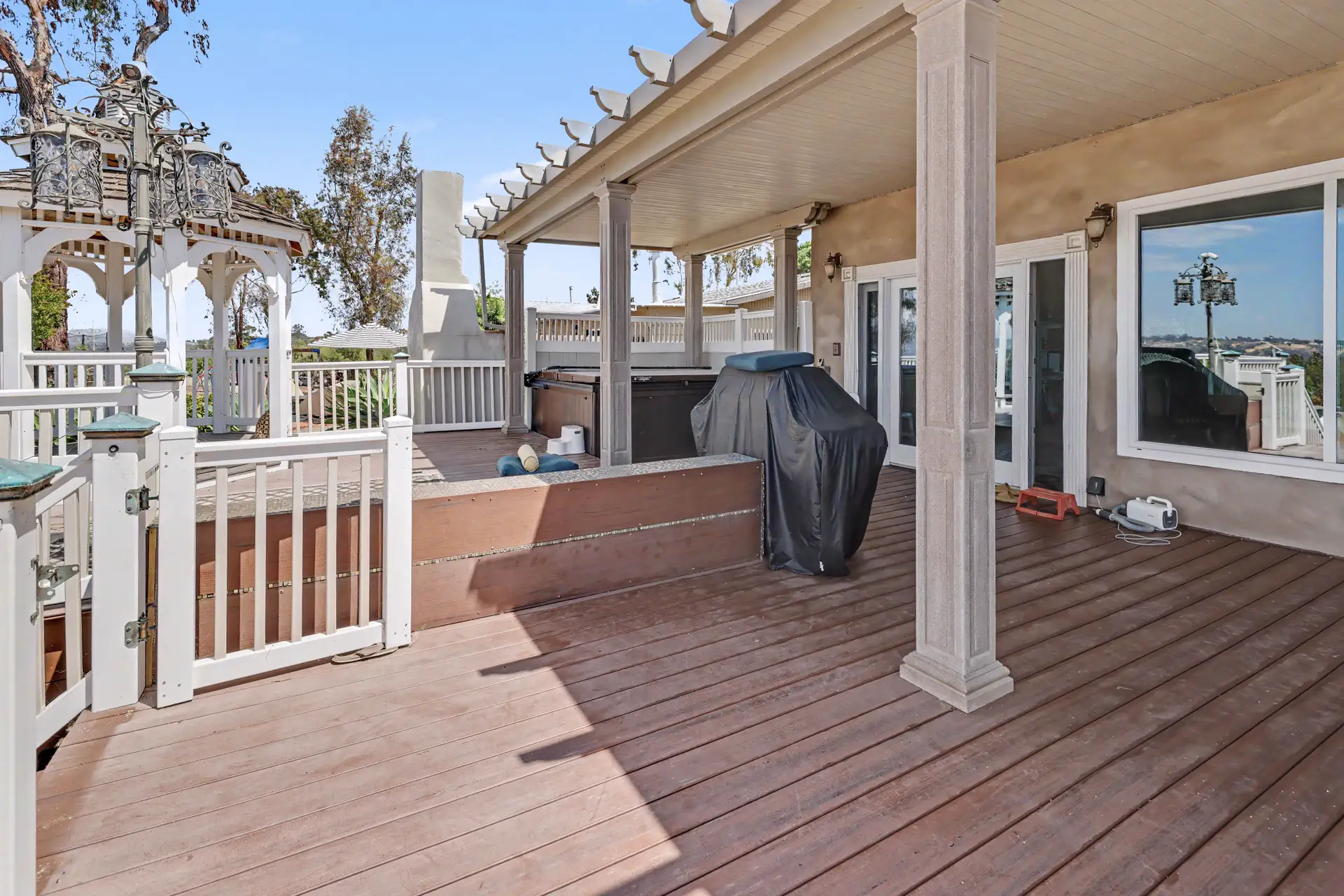 Covered deck with the gazebo and spa beyond, off the main residence.